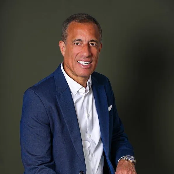 Smiling man in a blue suit and white shirt.