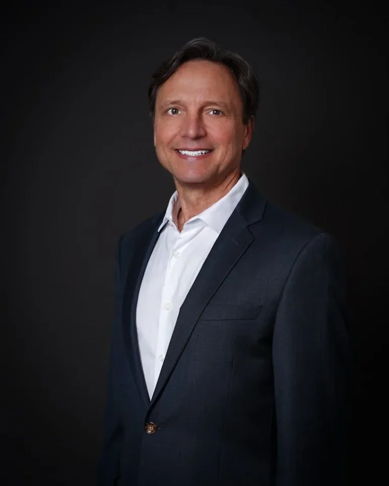 Smiling man in a suit and white shirt.