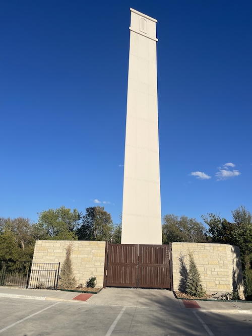 Tall white tower with brown gates.