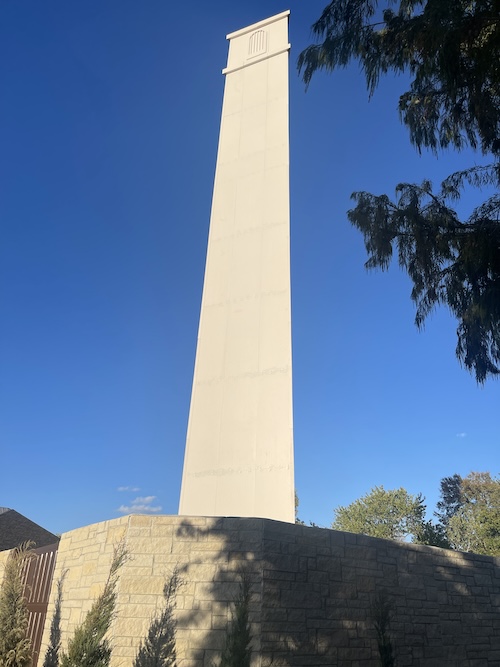 Tall white tower against blue sky.